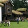 Visitantes que observan una fila de casas antiguas de madera con techos de césped